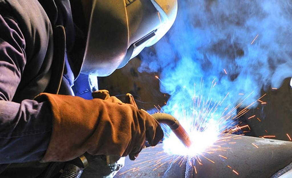 Trabalhador em ambiente industrial junto a bobinas de aço